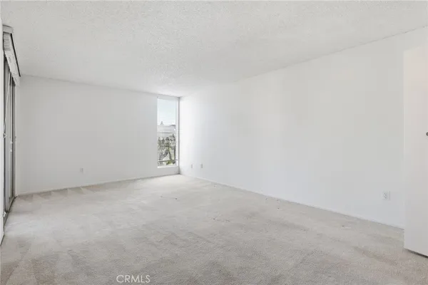 a view of an empty room with a kitchen