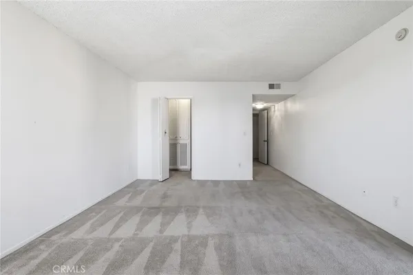 an empty room with windows and cabinet