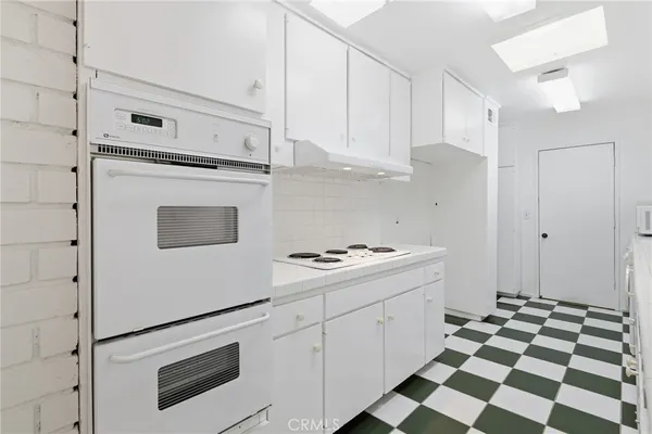 a kitchen with white cabinets and white appliances