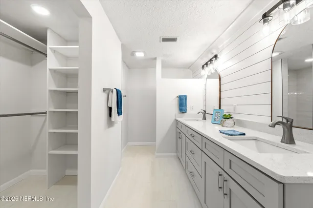 a bathroom with a double vanity sink a mirror and a shower