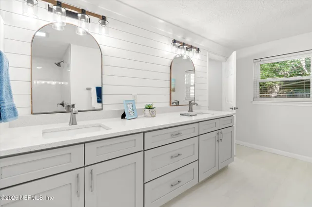 a bathroom with double vanity sink and a mirror