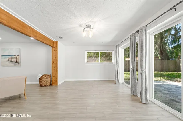 a view of a livingroom with wooden floor and a large window