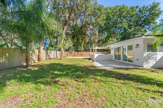 a view of a house with backyard and a tree