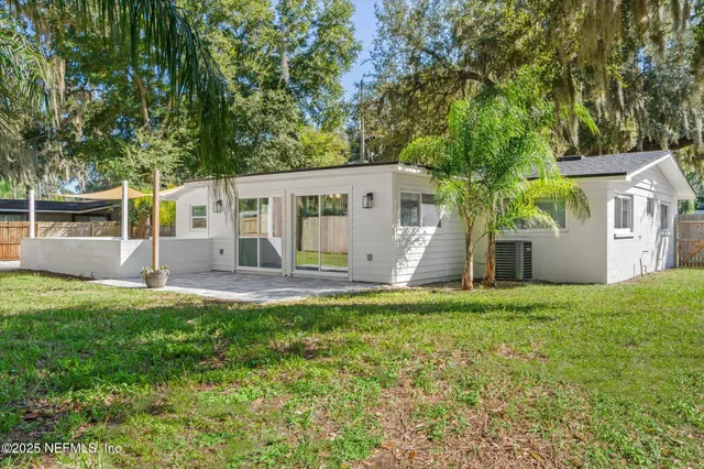 a view of a house with backyard and a tree