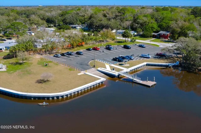an aerial view of a house with a garden and lake view