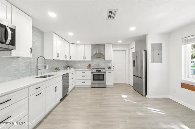 a kitchen with white cabinets and stainless steel appliances