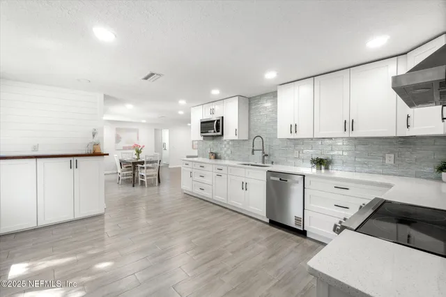 a kitchen with white cabinets and white appliances