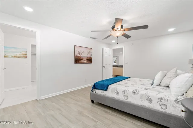 a bedroom with a bed and a ceiling fan