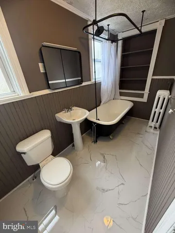 a bathroom with a toilet a sink and bathtub