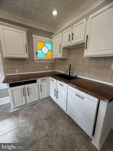 a kitchen with granite countertop a sink stainless steel appliances and cabinets