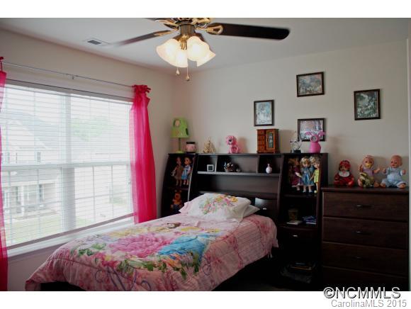 277 Roanoke Road Fletcher, NC 28732 - Photo 11 of 24 a bedroom with a bed and a chandelier