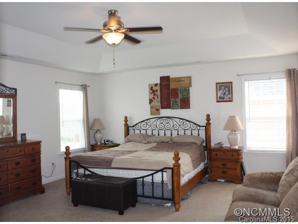 277 Roanoke Road Fletcher, NC 28732 - Photo 15 of 24 a bedroom with a bed and a chandelier