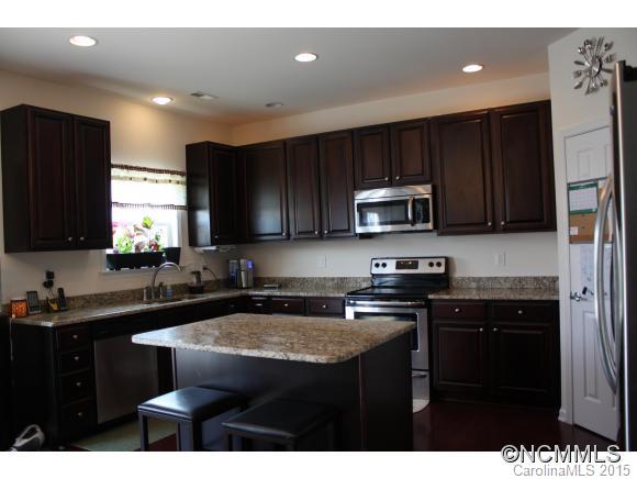 277 Roanoke Road Fletcher, NC 28732 - Photo 8 of 24 a kitchen with a sink a microwave a refrigerator and cabinets