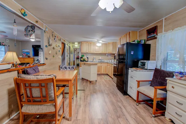 a kitchen with a dining table chairs refrigerator and cabinets