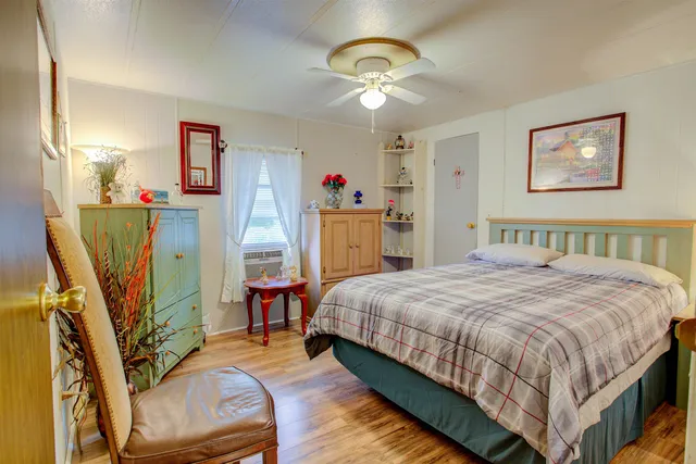 a bedroom with a bed and a flat tv screen on dresser