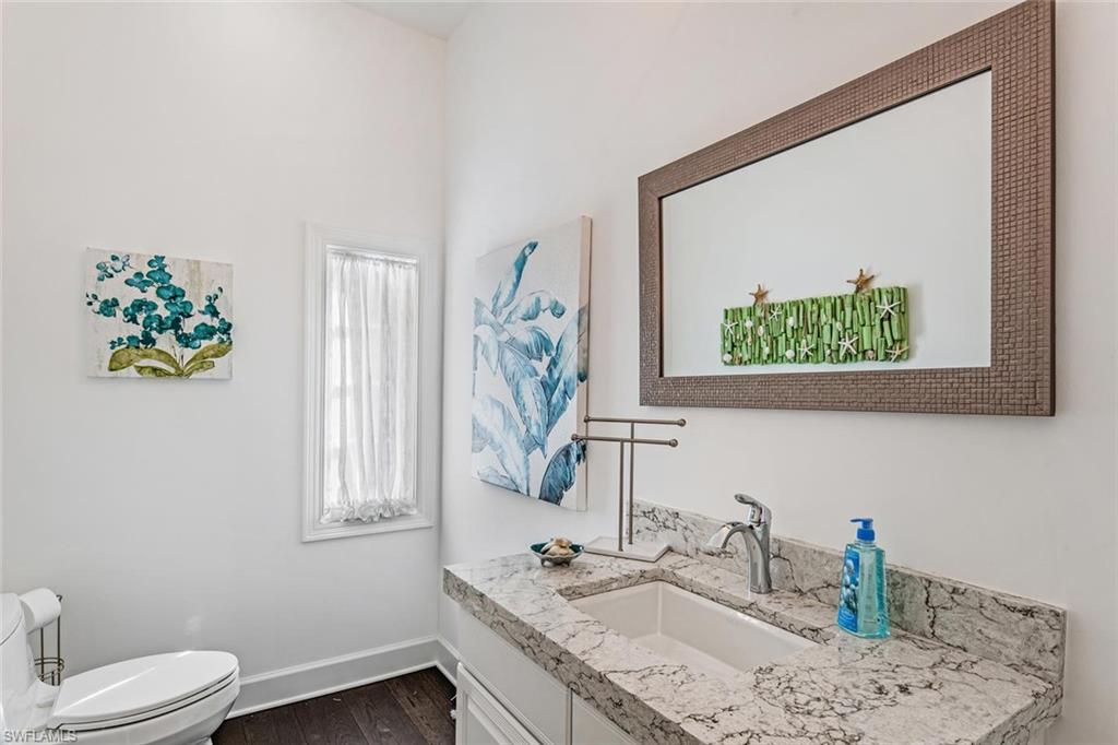 2540 Half Moon Walk Naples, FL 34102 - Photo 34 of 44 a bathroom with a granite countertop sink a toilet and a mirror