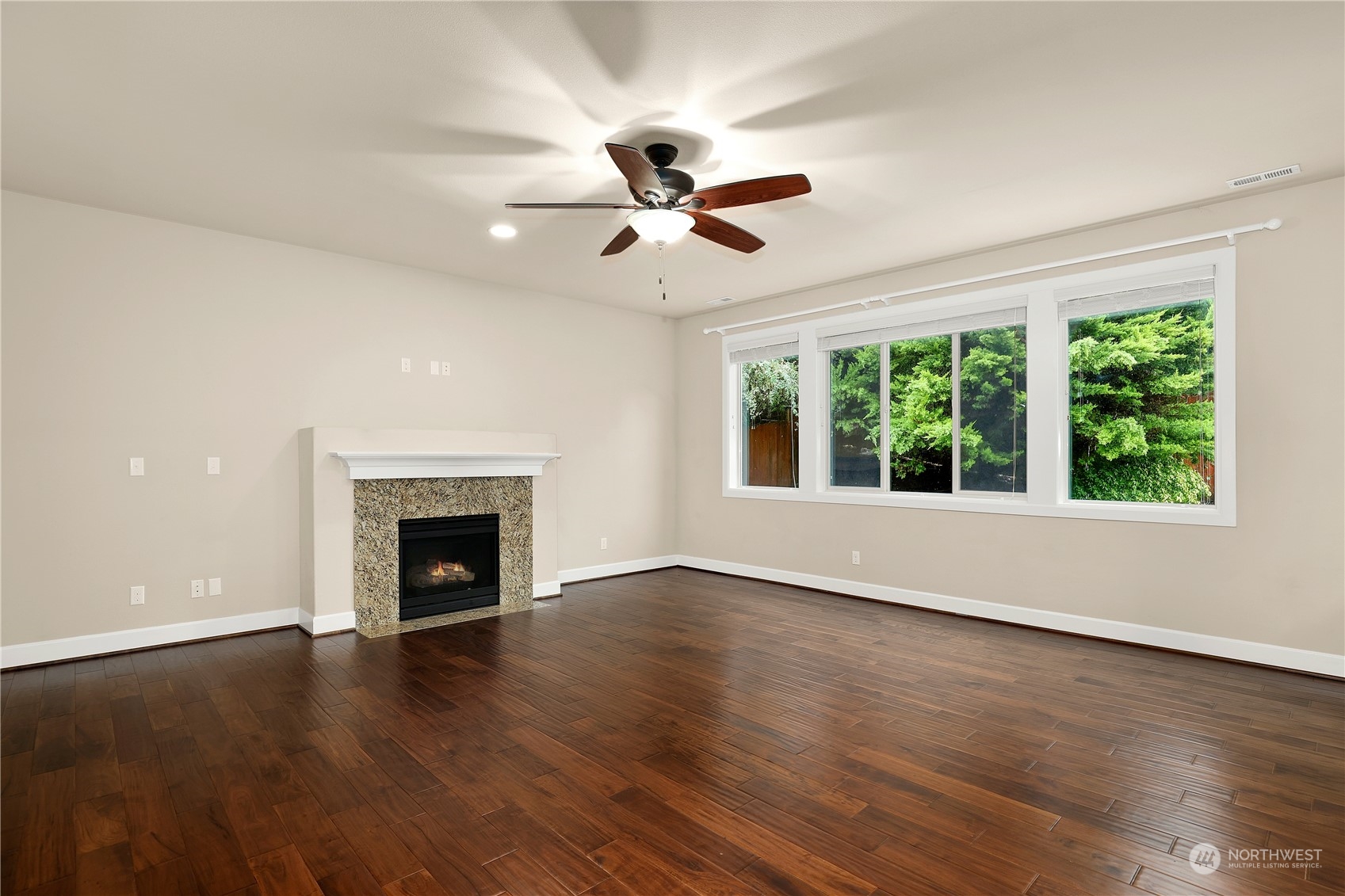 1592 Ridgeview Loop Southwest Tumwater, WA 98512 - Photo 4 of 40 a view of an empty room with wooden floor fireplace and a window