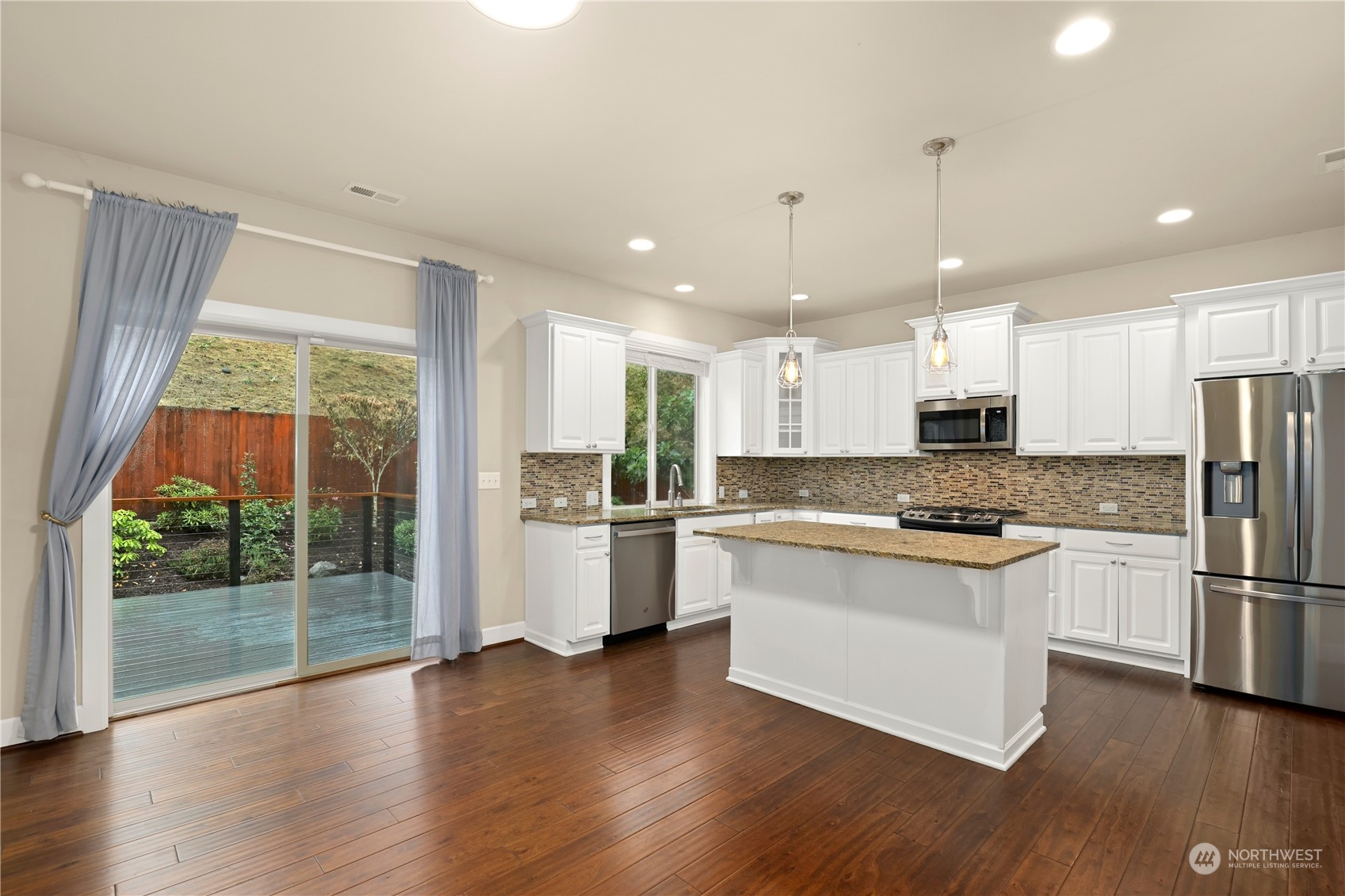 1592 Ridgeview Loop Southwest Tumwater, WA 98512 - Photo 6 of 40 a kitchen with stainless steel appliances granite countertop a refrigerator a stove top oven a sink and a large window