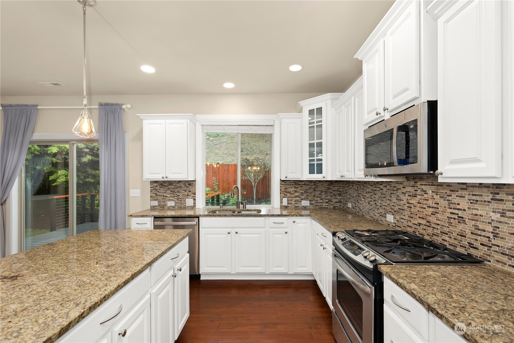 1592 Ridgeview Loop Southwest Tumwater, WA 98512 - Photo 9 of 40 a kitchen with stainless steel appliances granite countertop a stove a sink and a microwave