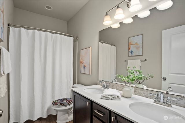 a bathroom with a sink a toilet and a large mirror