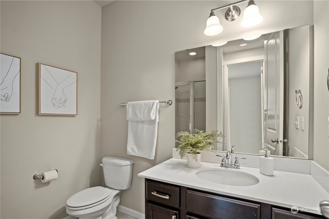 a bathroom with a sink vanity mirror and toilet