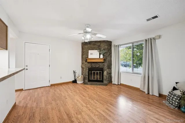 a view of an empty room with a window and fireplace