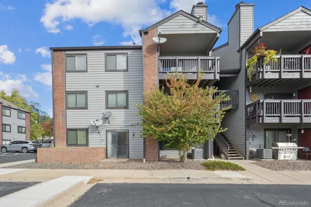 a front view of a building with a garden and plants