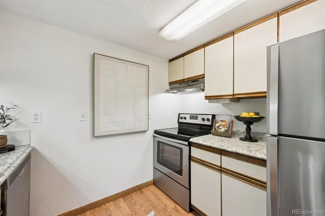 a kitchen with stainless steel appliances granite countertop a refrigerator sink and stove