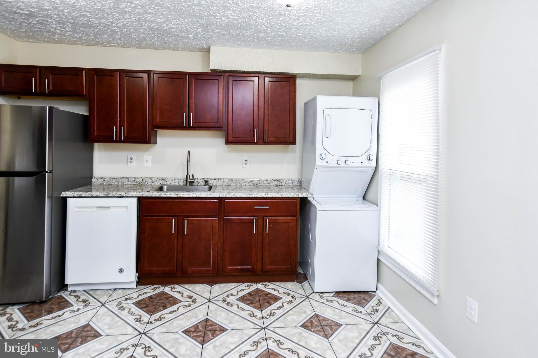 2115 North Anvil Lane Temple Hills, MD 20748 - Photo 9 of 37 a kitchen with granite countertop wooden cabinets and refrigerator