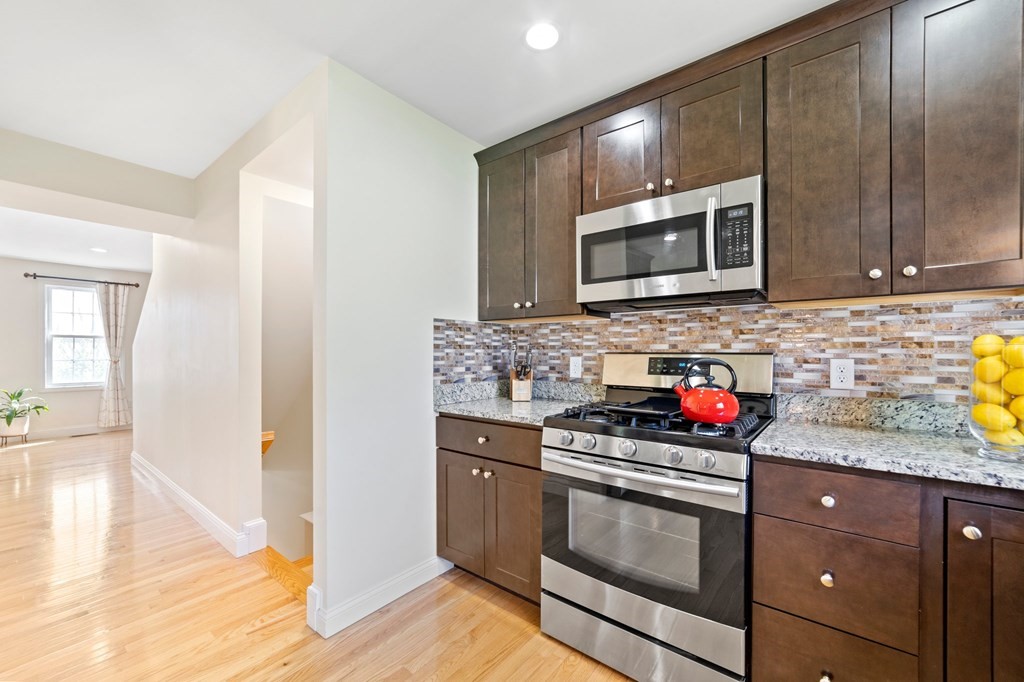 311 Littleton Road, Unit 60 Chelmsford, MA 01824 - Photo 18 of 42 a kitchen with stainless steel appliances granite countertop a stove a microwave and a sink