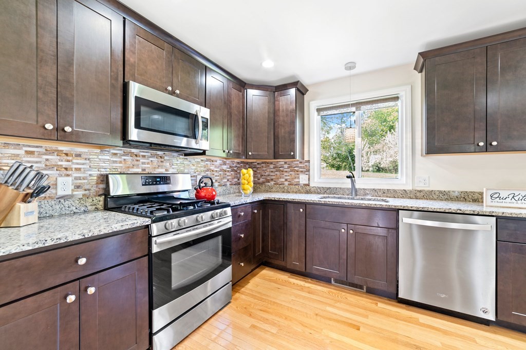 311 Littleton Road, Unit 60 Chelmsford, MA 01824 - Photo 19 of 42 a kitchen with stainless steel appliances granite countertop a stove a sink and a microwave