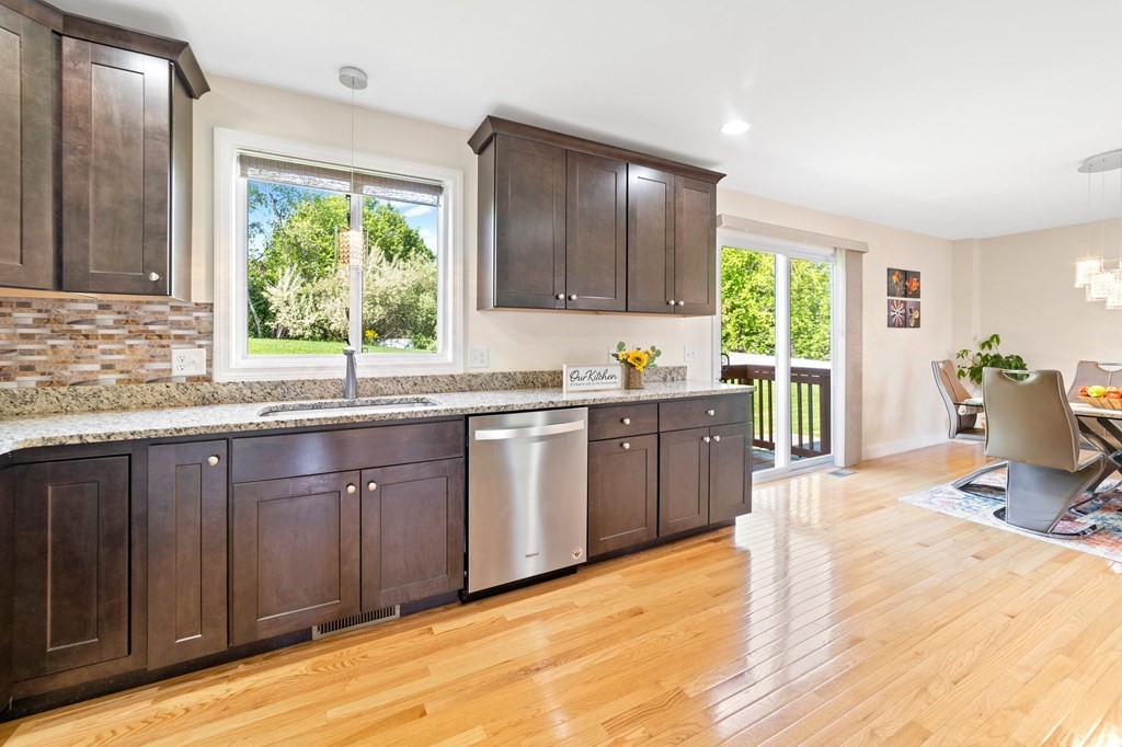 311 Littleton Road, Unit 60 Chelmsford, MA 01824 - Photo 20 of 42 a large kitchen with kitchen island granite countertop a large window and cabinets