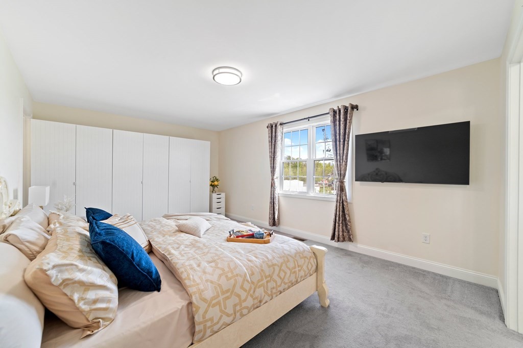 311 Littleton Road, Unit 60 Chelmsford, MA 01824 - Photo 24 of 42 a bedroom with a bed and a flat screen tv