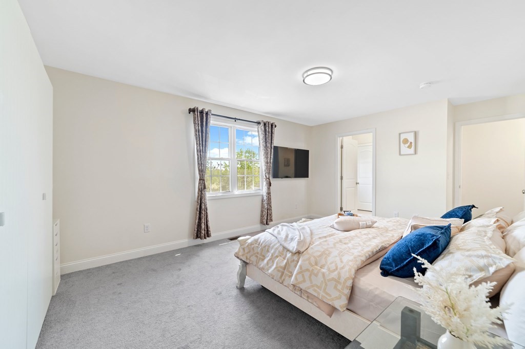 311 Littleton Road, Unit 60 Chelmsford, MA 01824 - Photo 26 of 42 a bedroom with a bed and a flat screen tv