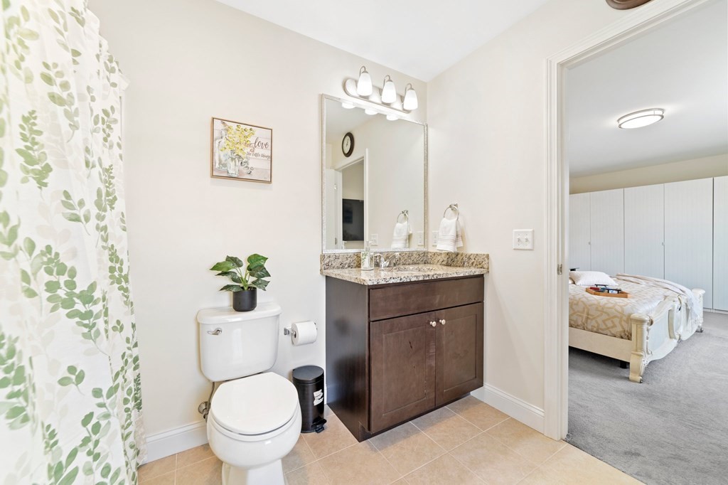 311 Littleton Road, Unit 60 Chelmsford, MA 01824 - Photo 27 of 42 a bathroom with a granite countertop toilet sink and mirror