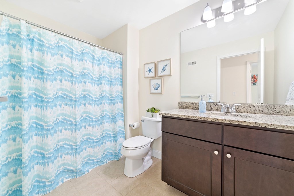 311 Littleton Road, Unit 60 Chelmsford, MA 01824 - Photo 33 of 42 a bathroom with a granite countertop toilet sink and mirror