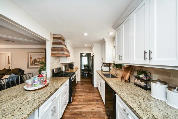 a kitchen with sink stove and living room