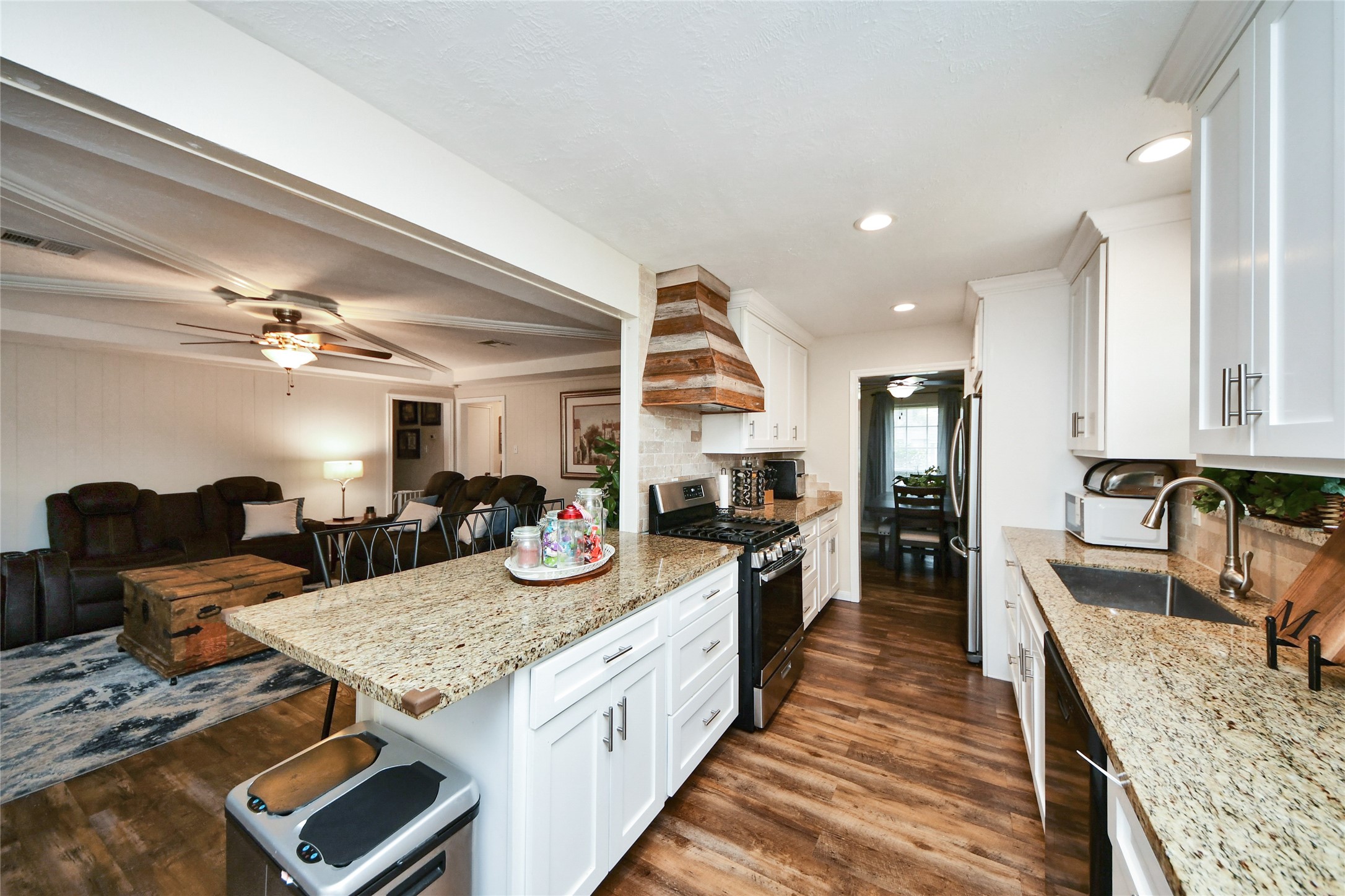 203 Ridgewood Drive Oak Ridge North, TX 77386 - Photo 13 of 39 a kitchen with sink stove and living room