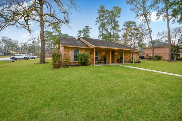 a view of a house with a big yard and large trees
