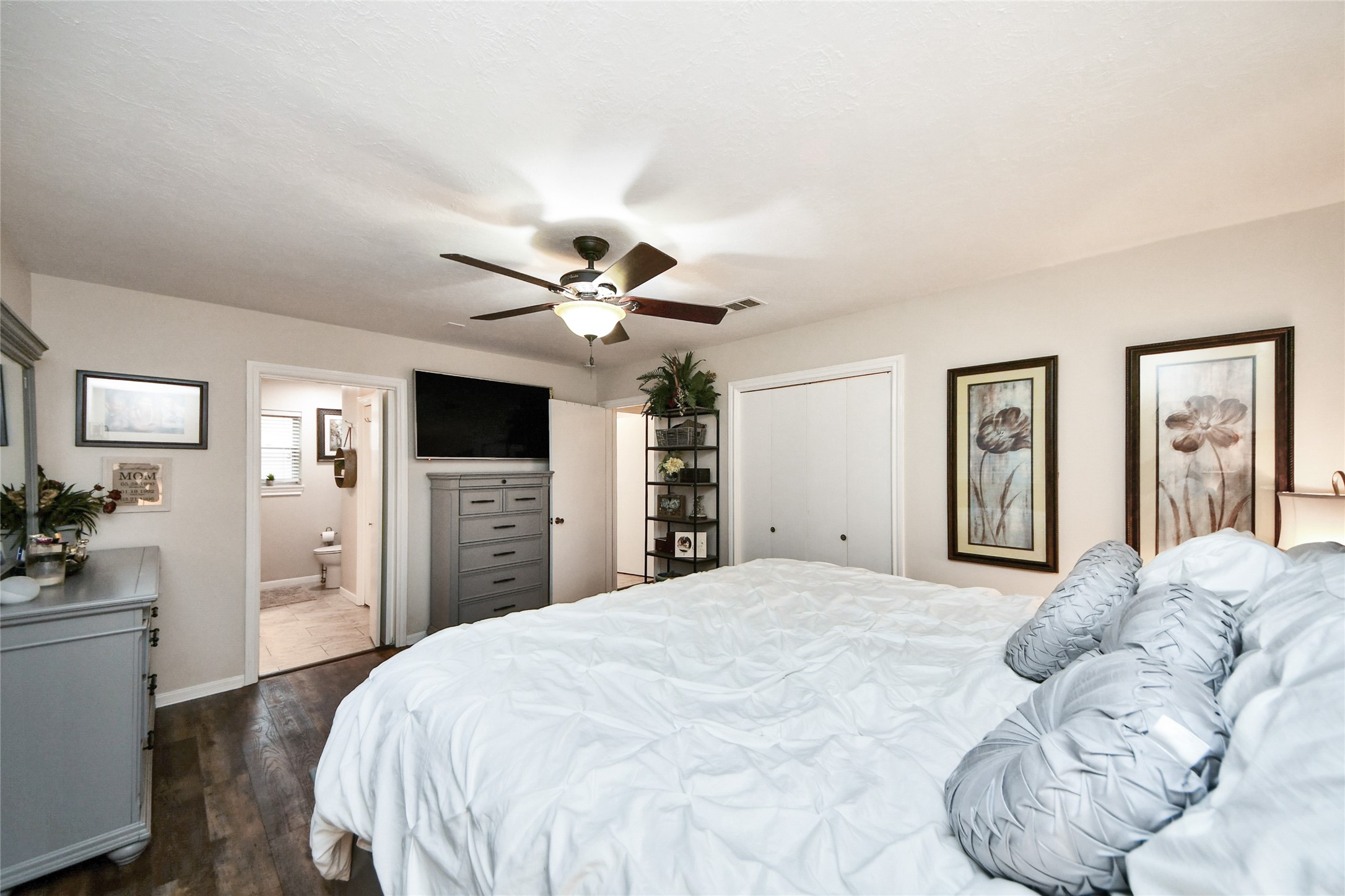 203 Ridgewood Drive Oak Ridge North, TX 77386 - Photo 24 of 39 a bedroom with a large bed and a chandelier