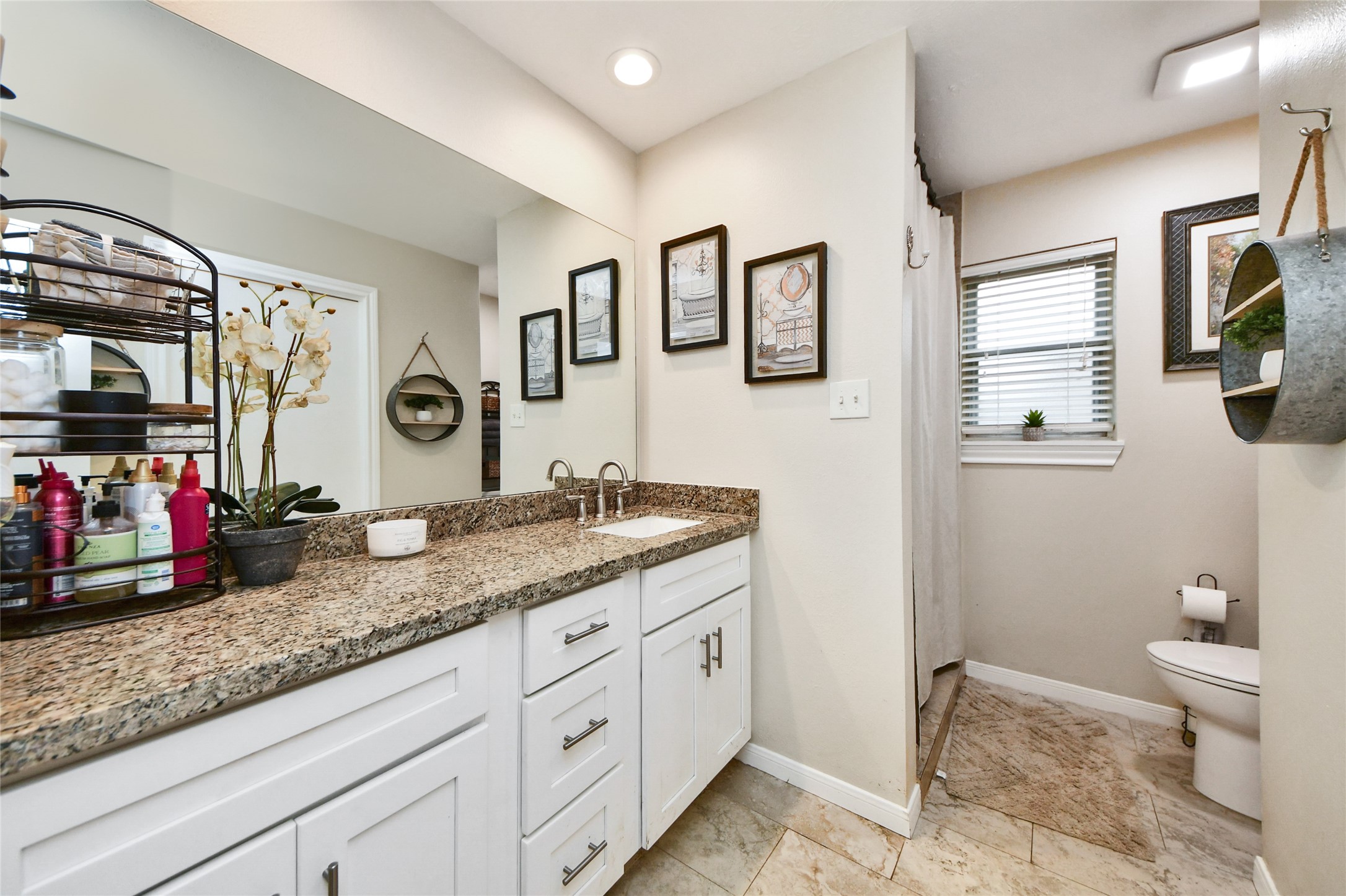 203 Ridgewood Drive Oak Ridge North, TX 77386 - Photo 25 of 39 a bathroom with a granite countertop double vanity sink a mirror and a toilet