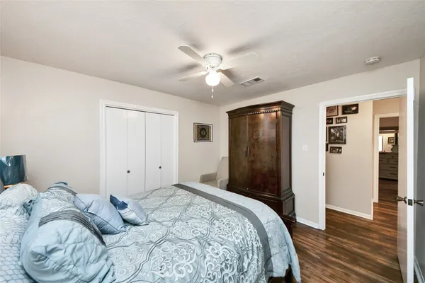 a large bedroom with a bed and a flat tv screen on dresser