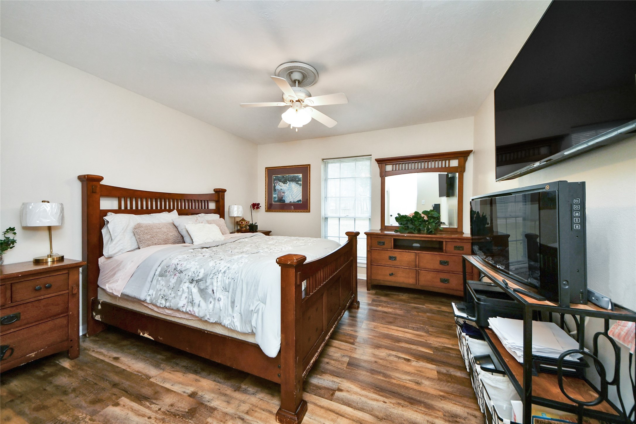 203 Ridgewood Drive Oak Ridge North, TX 77386 - Photo 28 of 39 a large bedroom with a bed and a flat tv screen on dresser