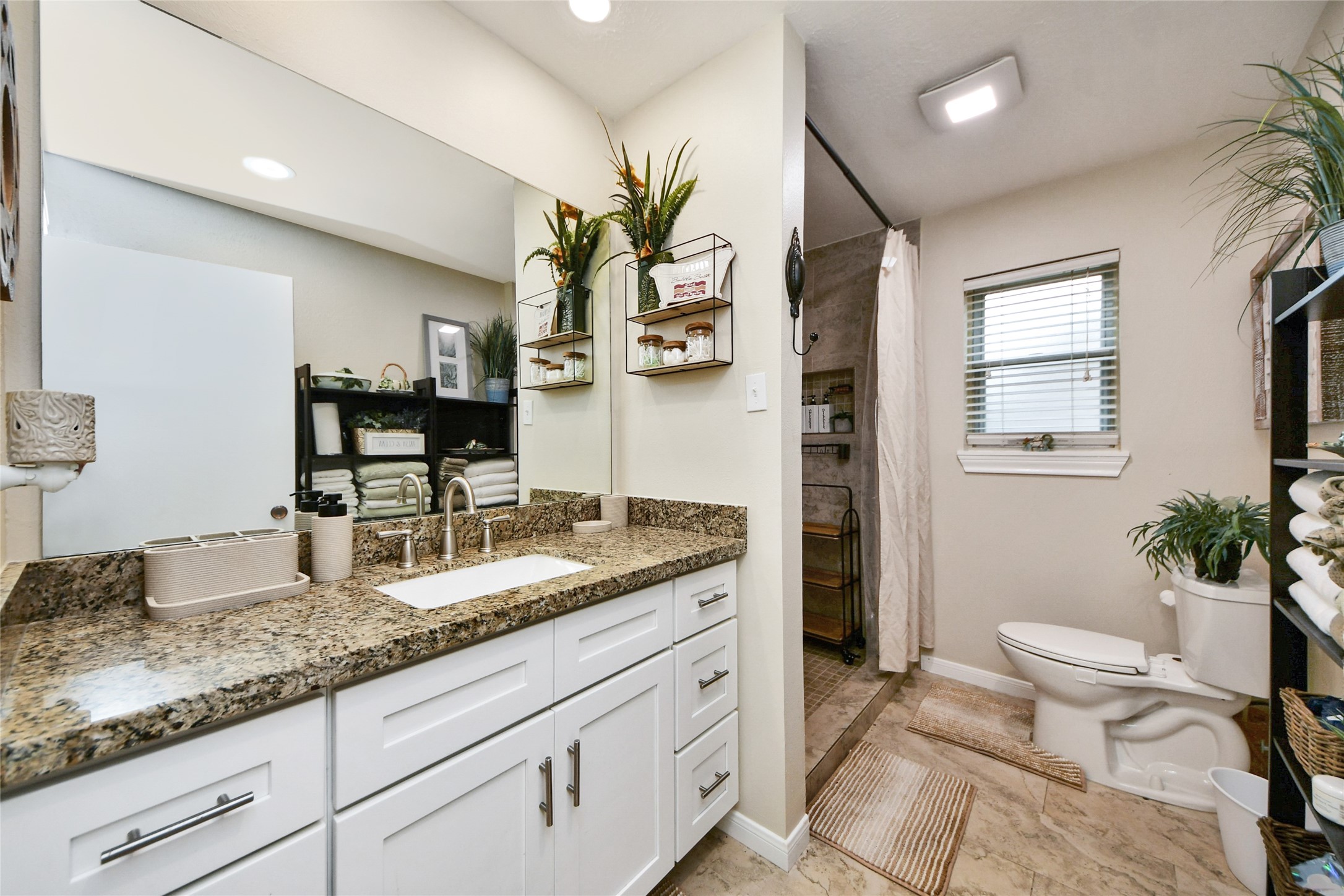 203 Ridgewood Drive Oak Ridge North, TX 77386 - Photo 30 of 39 a bathroom with a granite countertop sink and a mirror