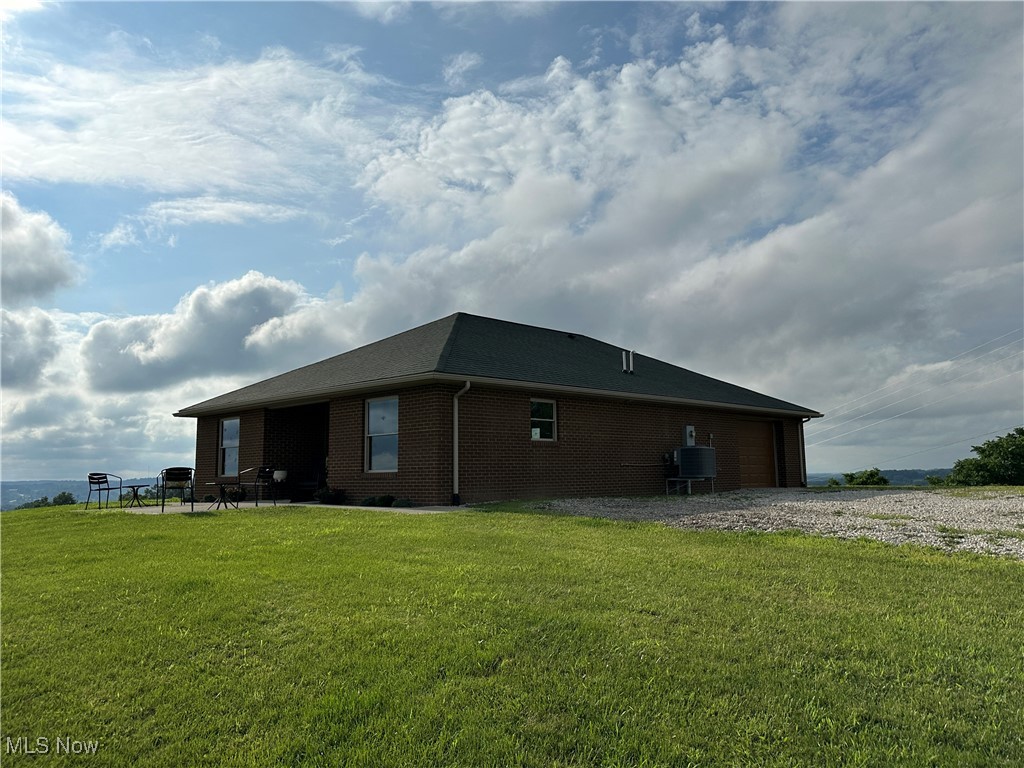 18331 Davis Ridge Road Caldwell, OH 43724 - Photo 30 of 31 View of property exterior featuring brick siding and a lawn