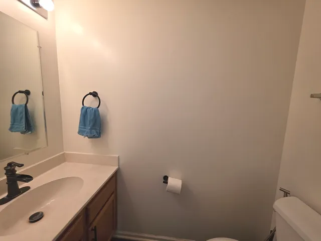 a bathroom with a sink and mirror with toilet
