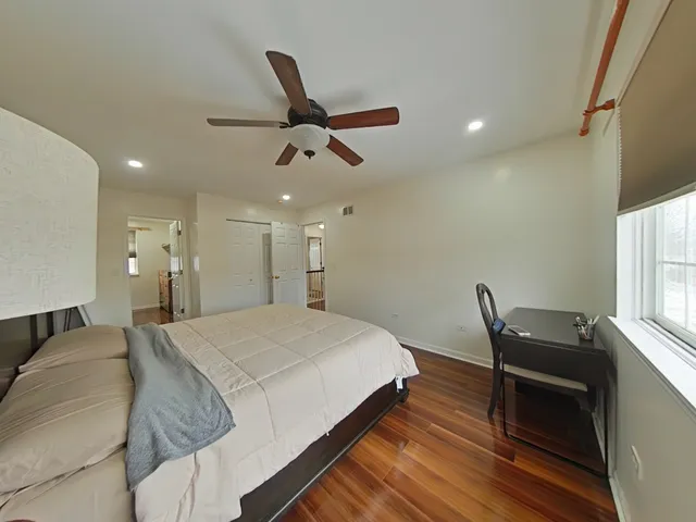 a bed room with a bed and a ceiling fan