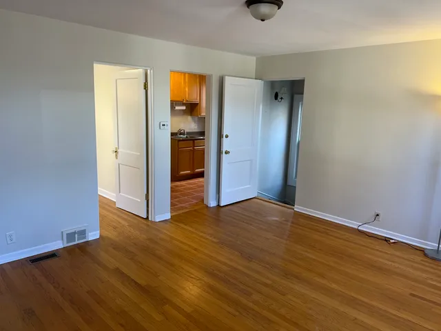 an empty room with wooden floor and closet