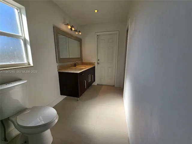 a bathroom with a granite countertop sink a toilet and bathtub