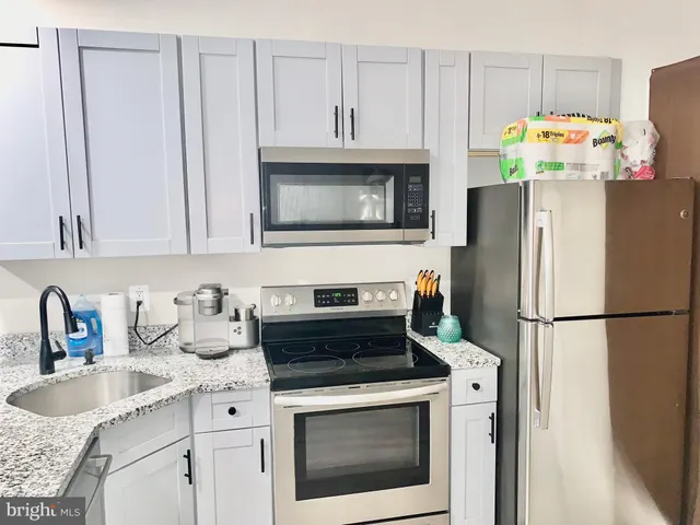 a kitchen with stainless steel appliances granite countertop a refrigerator sink stove and microwave